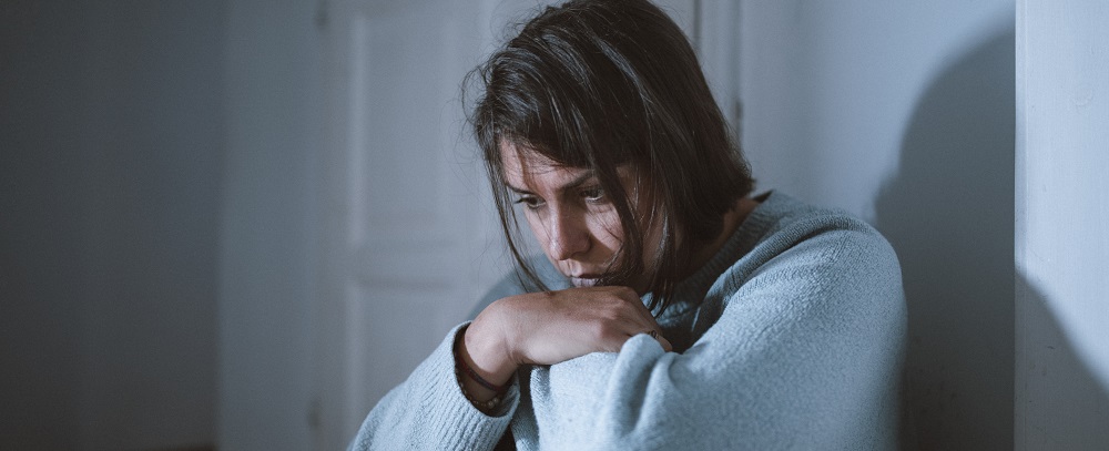 sad woman sitting in front of a door