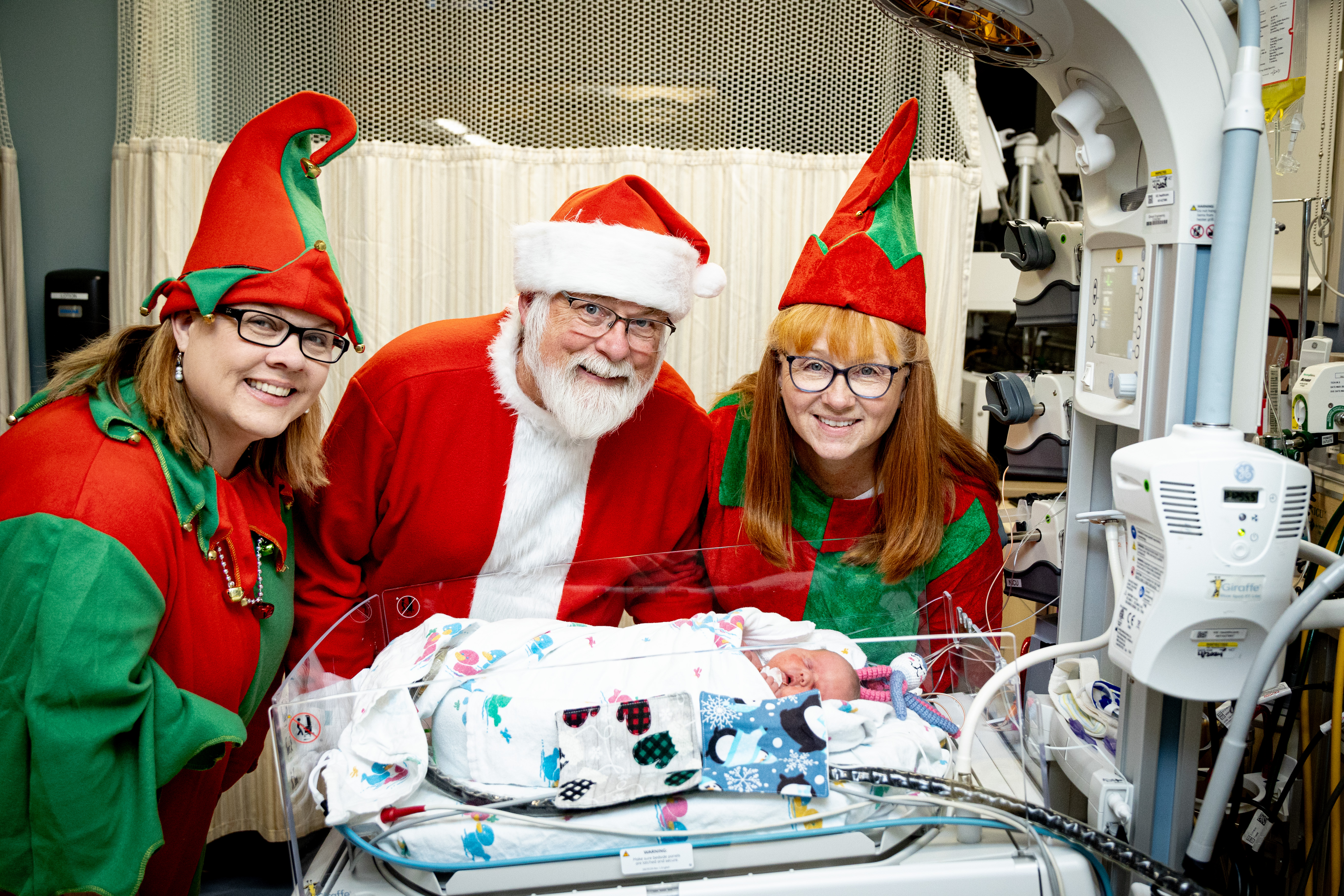 Santa and his elves visit with a NICU patient.