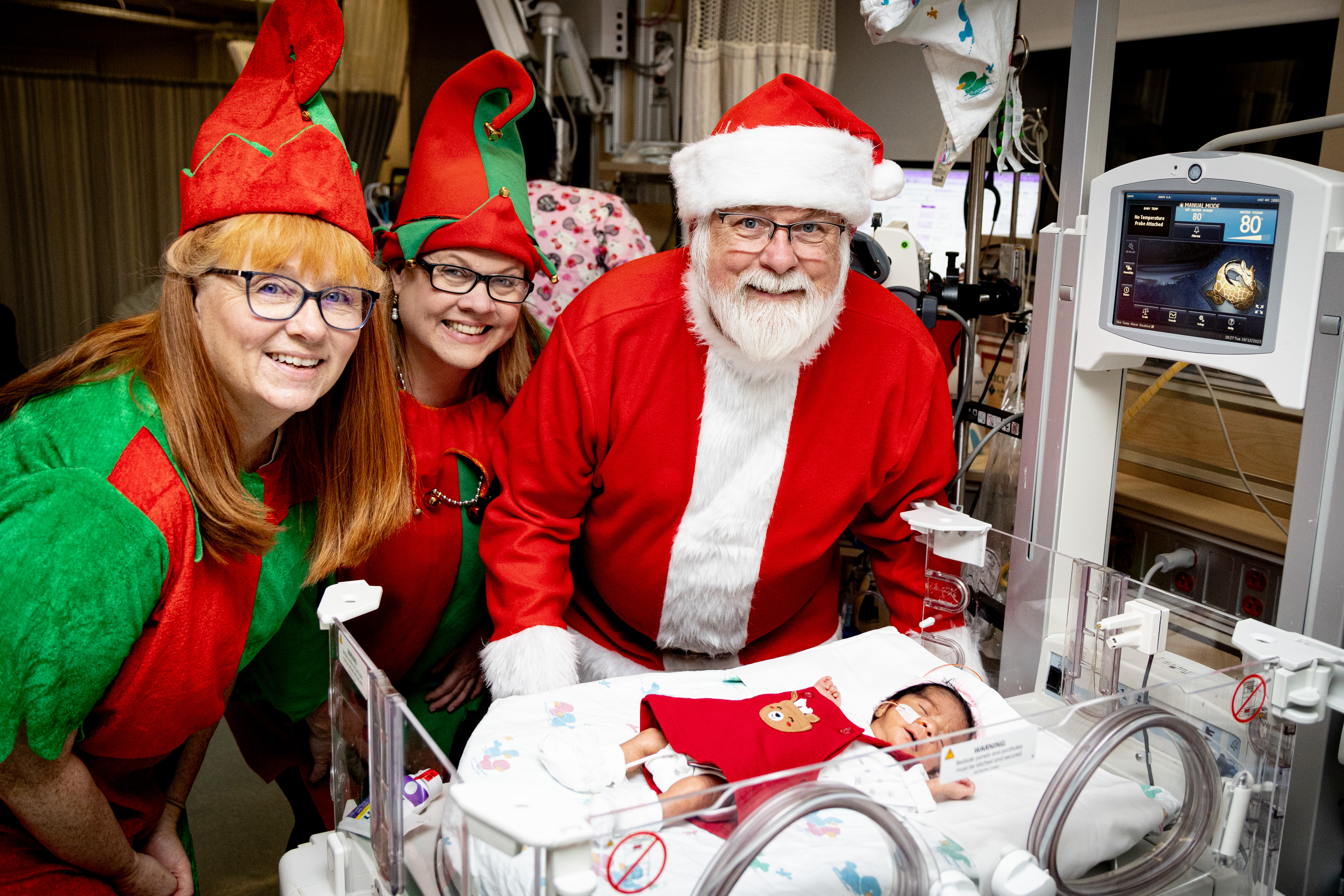 Santa and his elves visit with a NICU patient.
