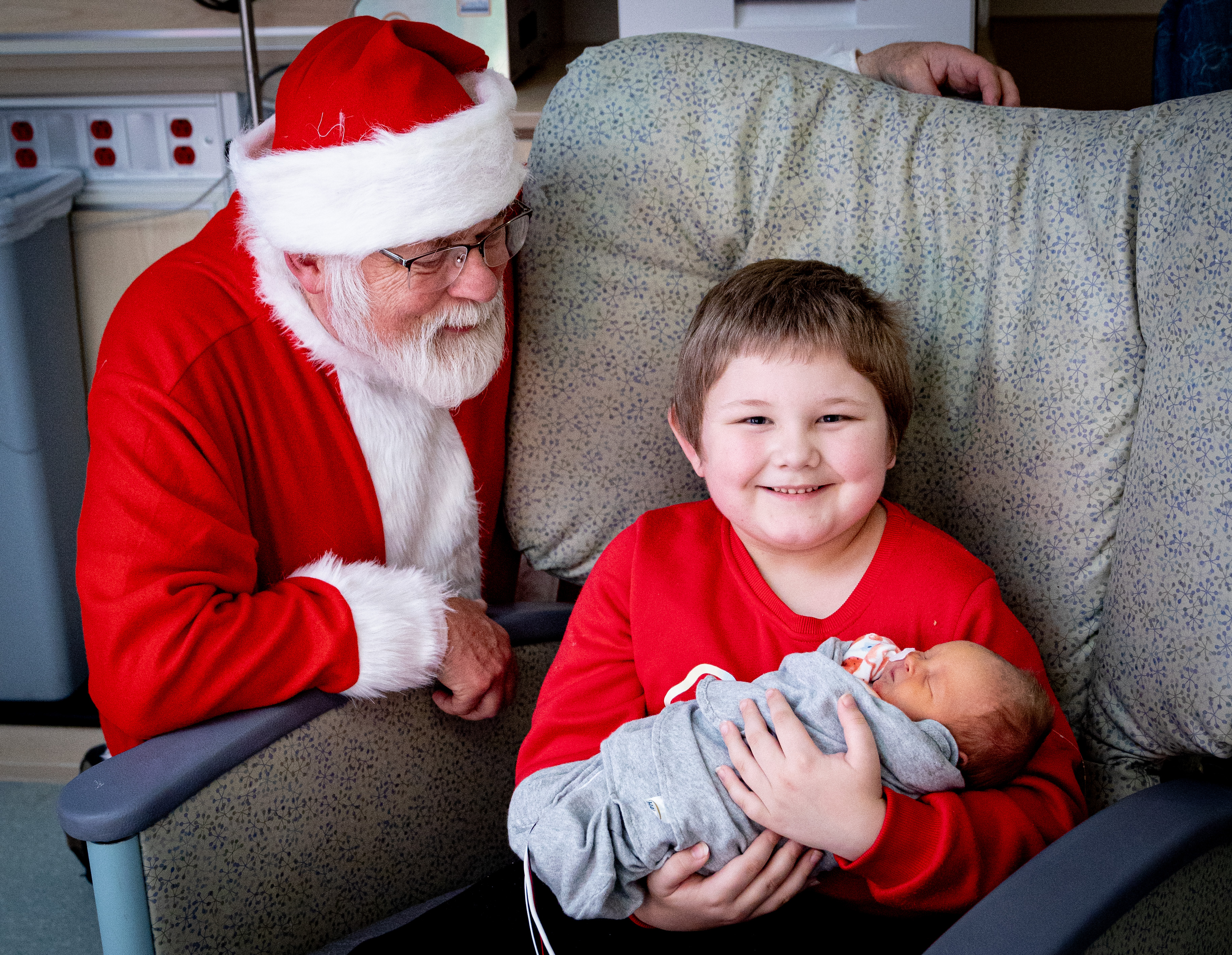 Santa visits with a NICU patient and a family member.