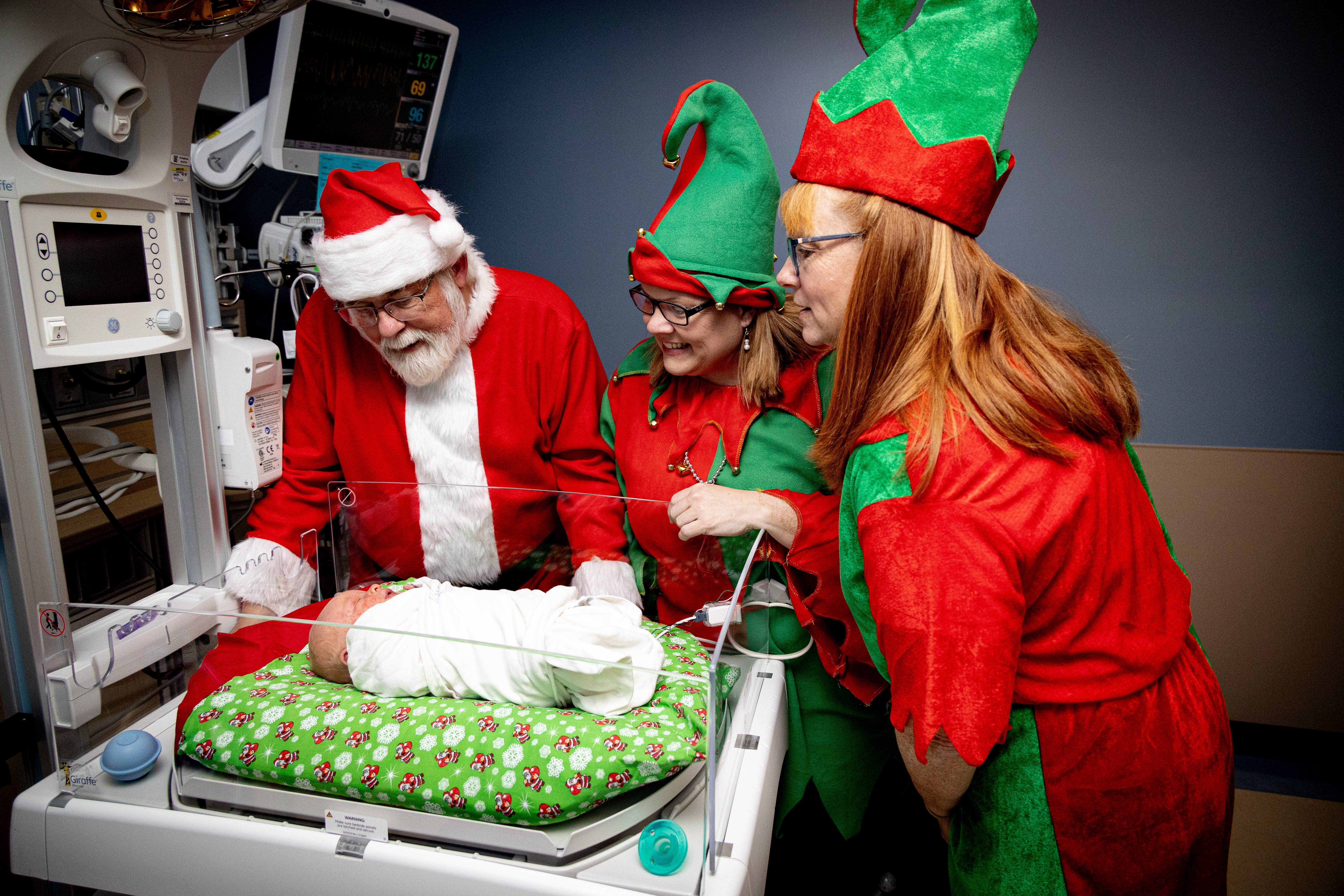 Santa and his elves visit with a NICU patient.