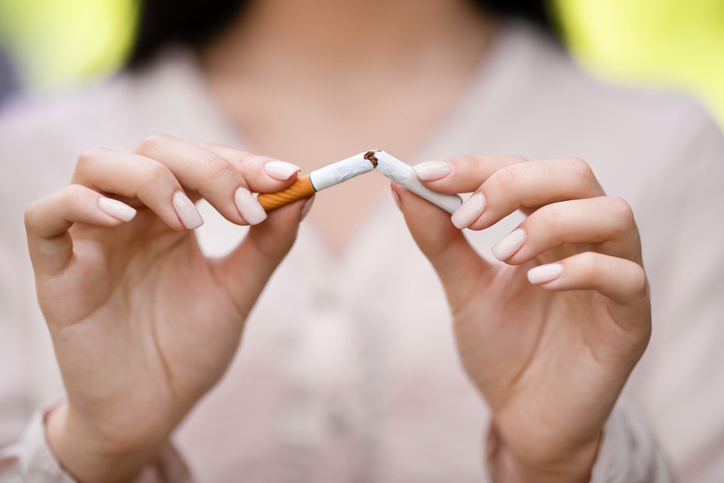 A person breaking a cigarette in half.