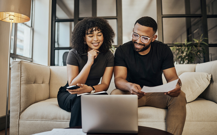 Two people sitting in front of a laptop.