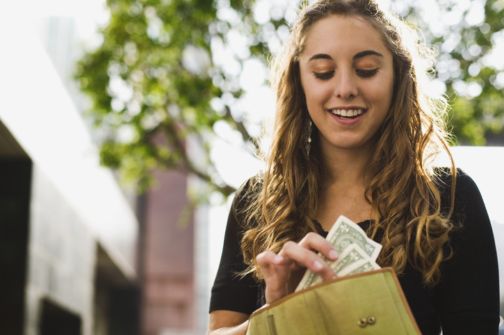 A woman counting the cash in her wallet.