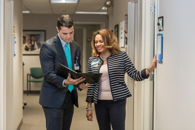 Two Carilion leaders demonstration collaboration in a facility hallway.