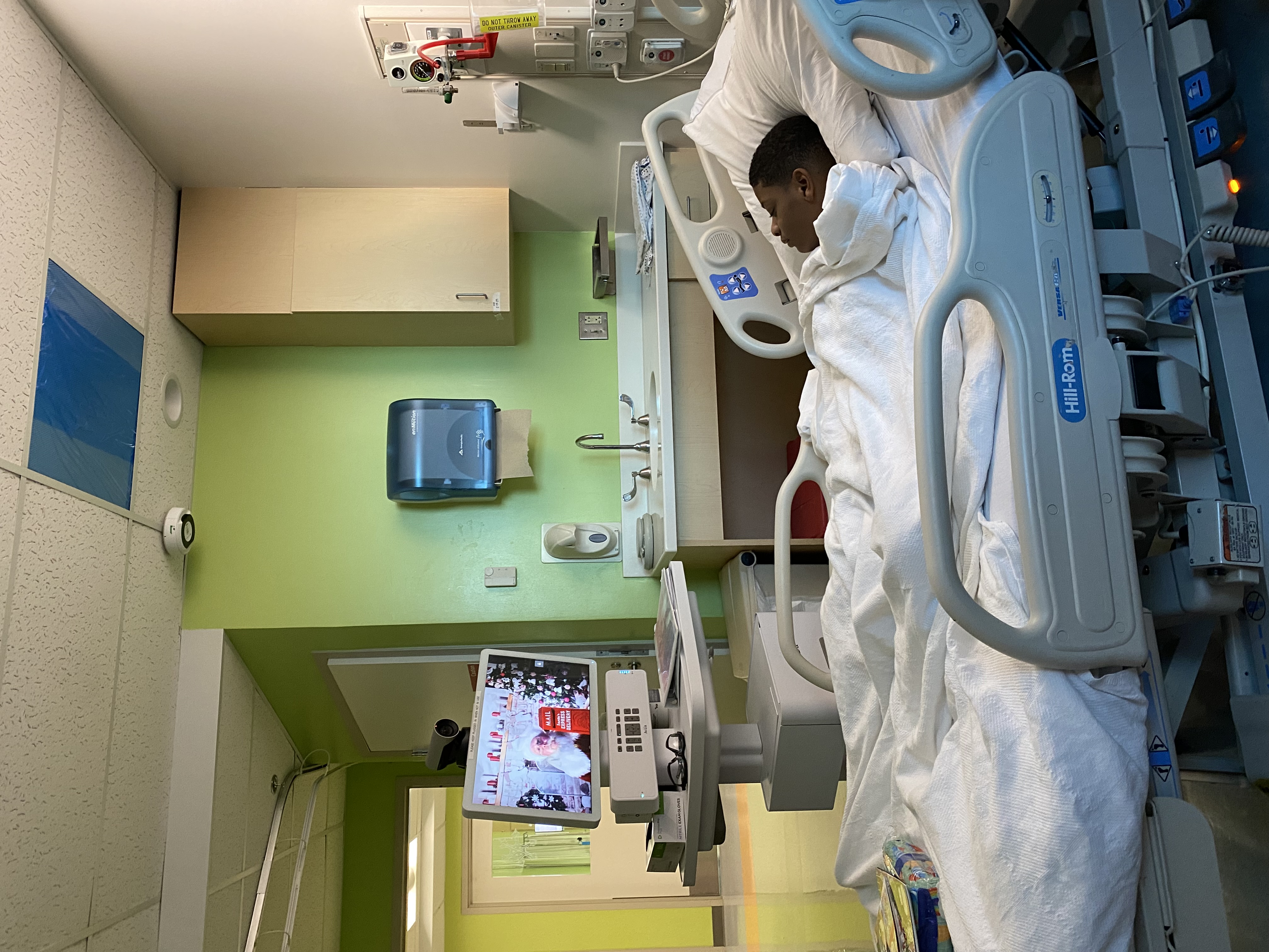 Santa visits with a pediatric patient virtually.