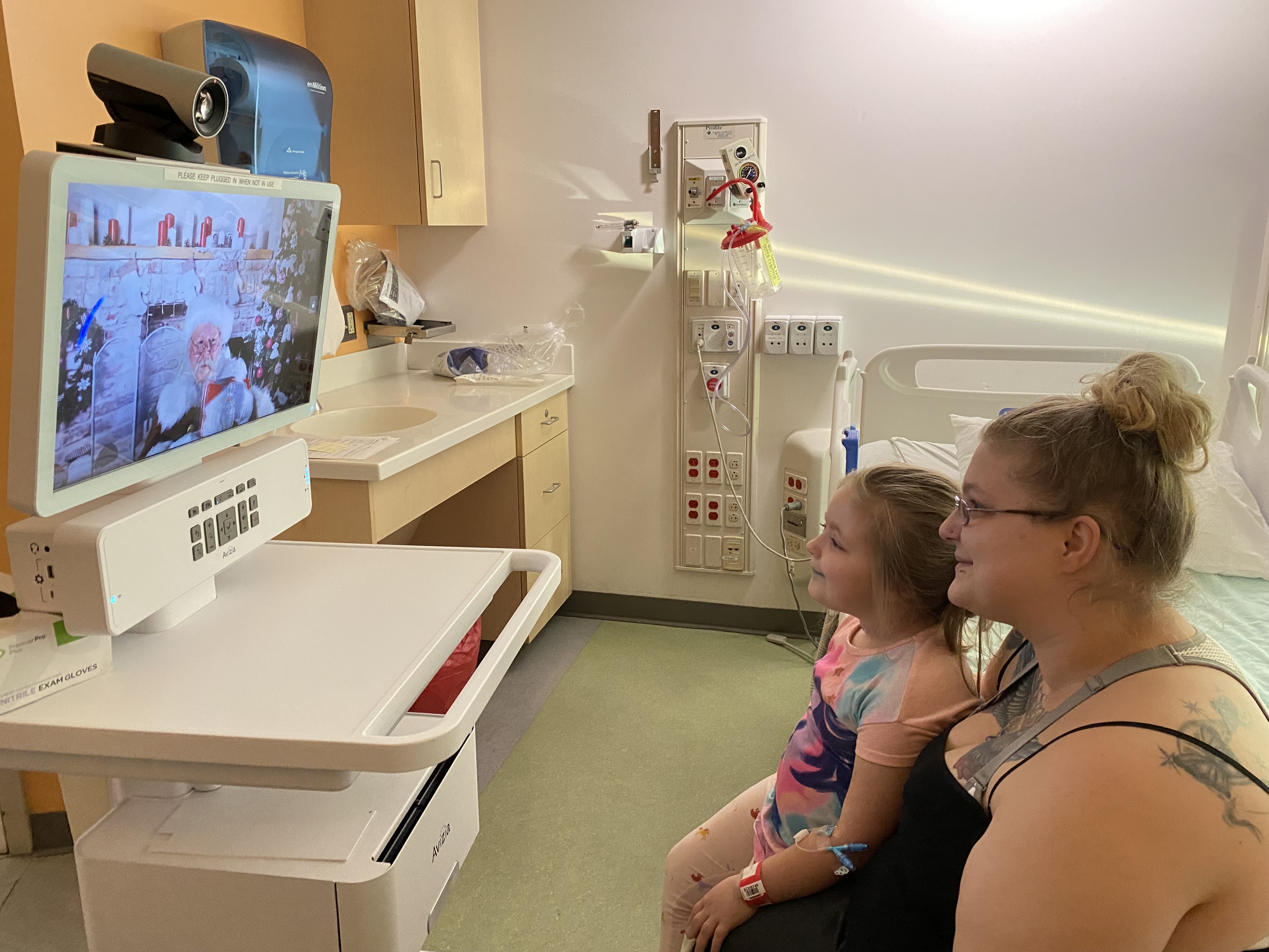 Santa visits with a pediatric patient virtually.