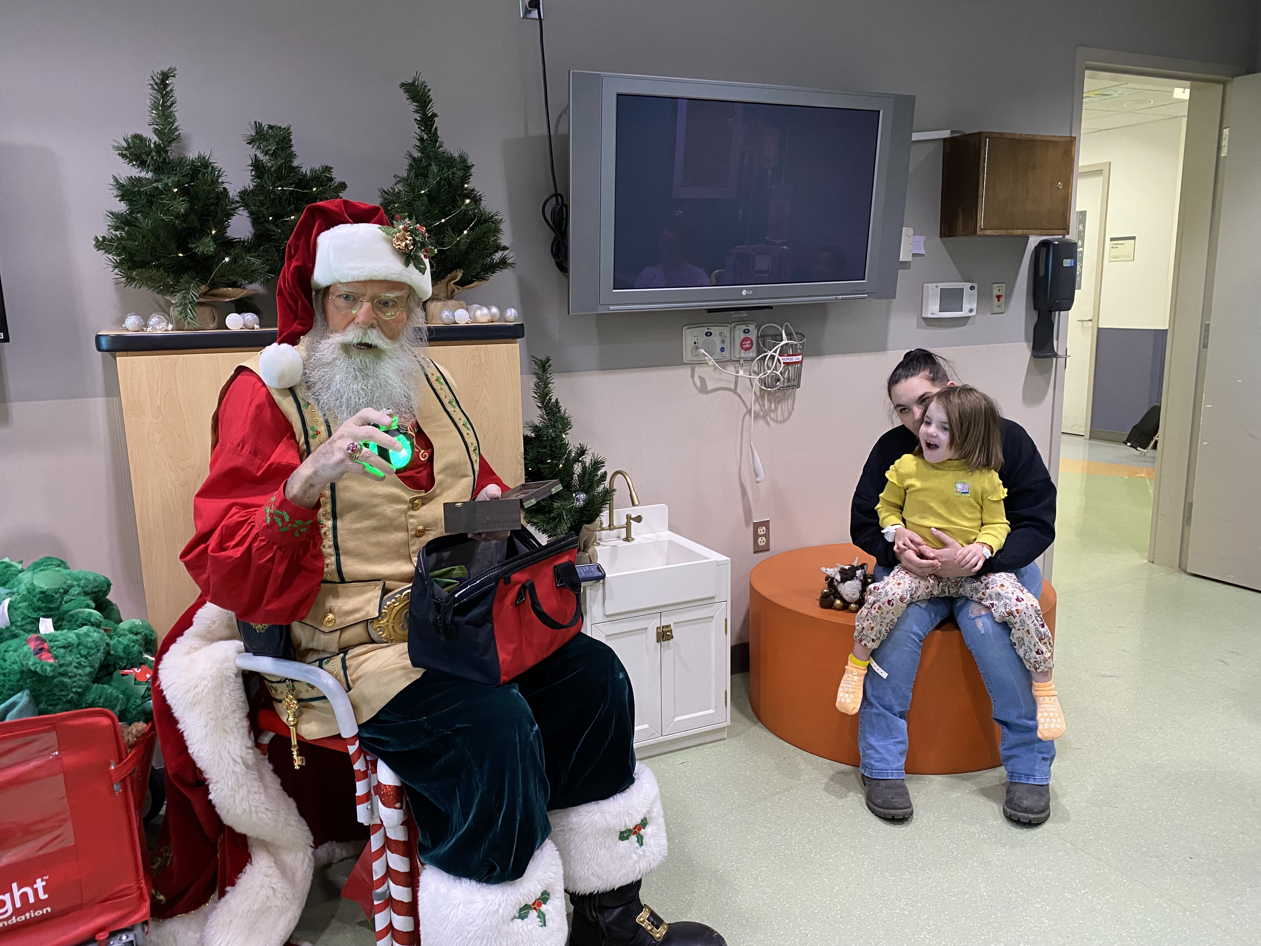 Santa visits with a pediatric patient and their family.