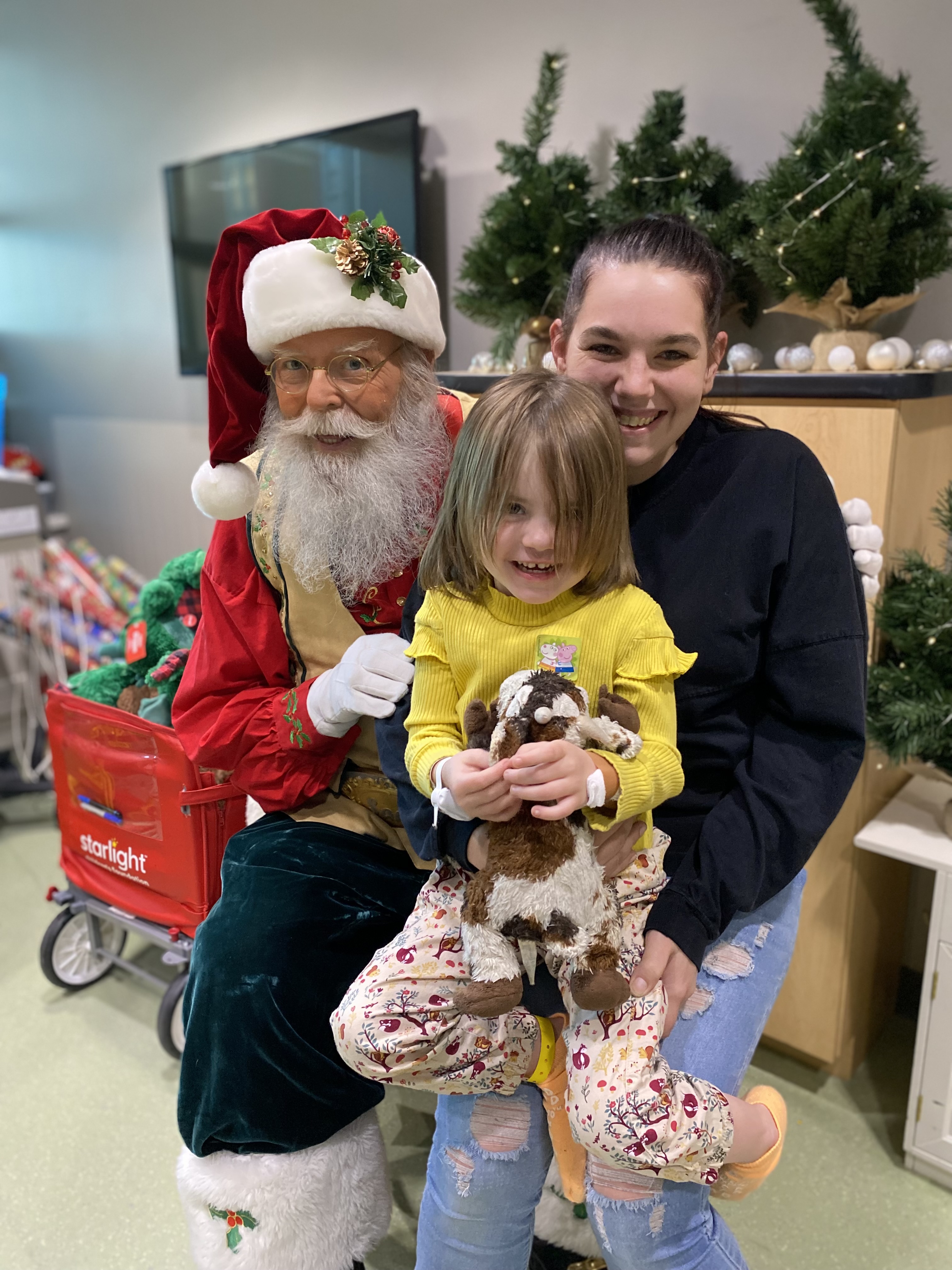 Santa visits with a pediatric patient and their family.