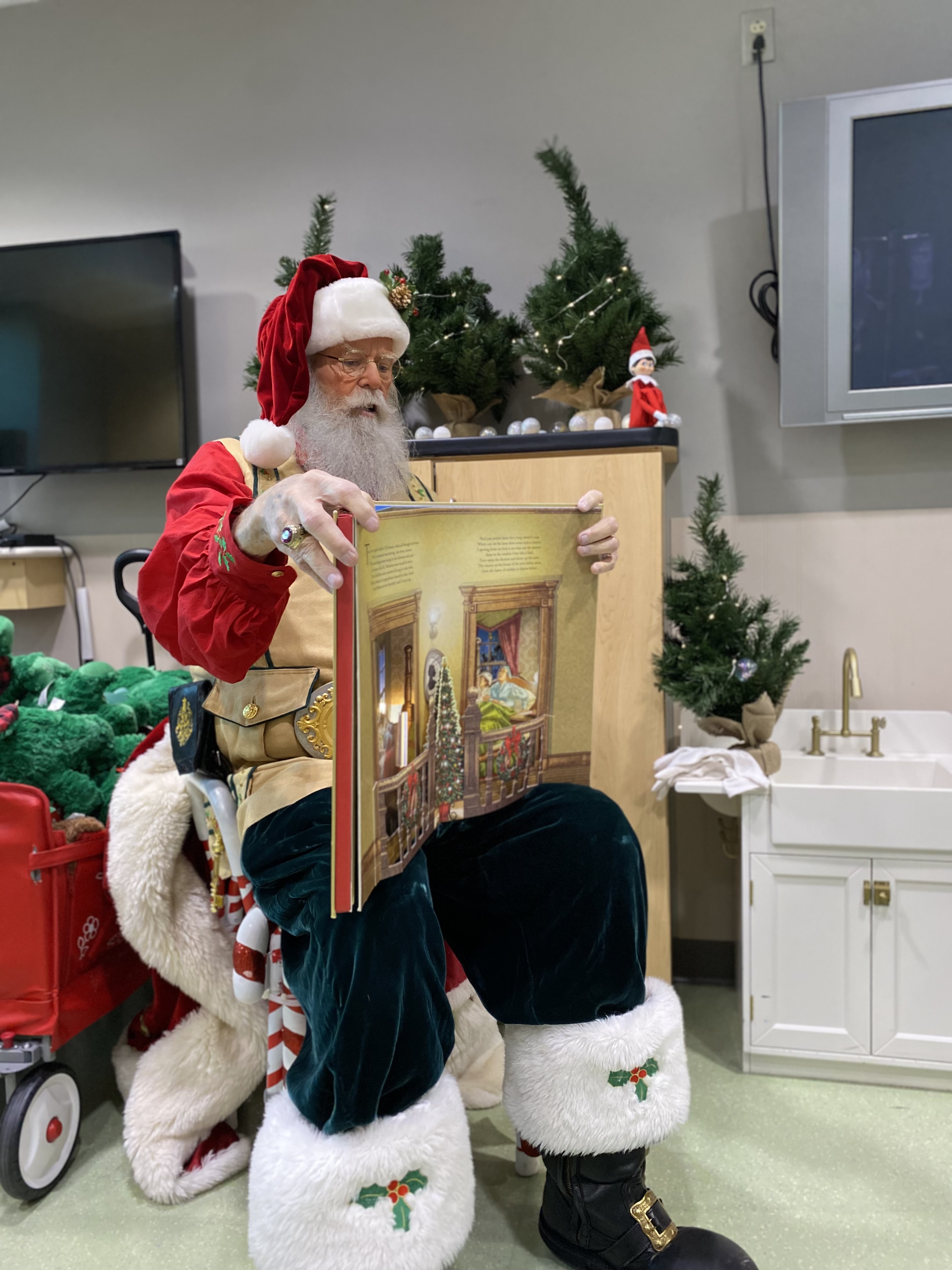 Santa reads a story to pediatric patients. 