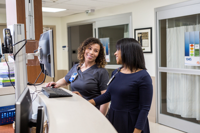 Two Carilion staff standing in front of a computer.