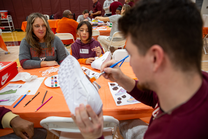 Virginia Tech Men's Basketball player Hunter Cattoor working on painting a sneaker. 