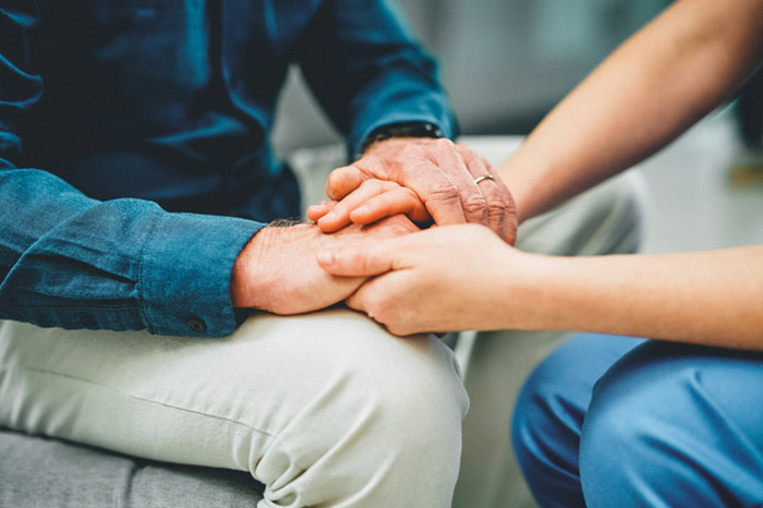 Family members holding hands to support one another.