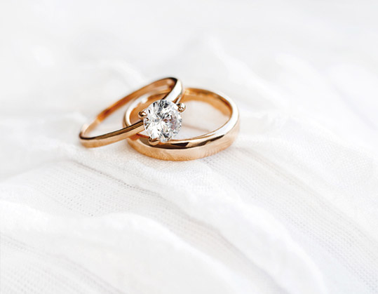 A pair of wedding rings sitting on top of a white cloth.
