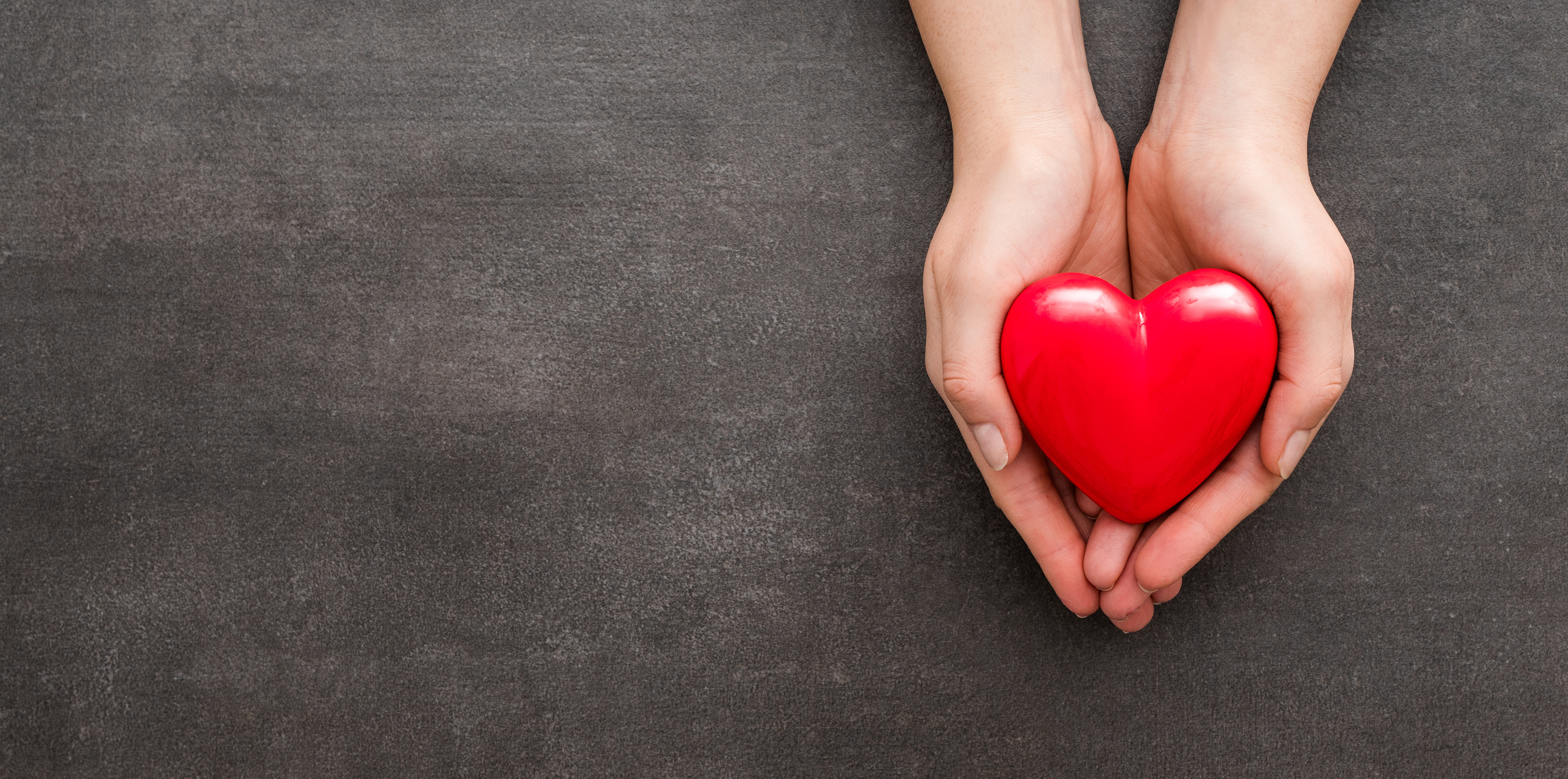 stock image of hands holding red heart