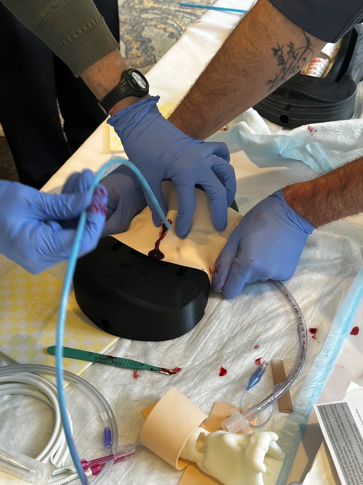 Emergency Medicine physicians train to perform cricothyrotomy using a device created by our teams.