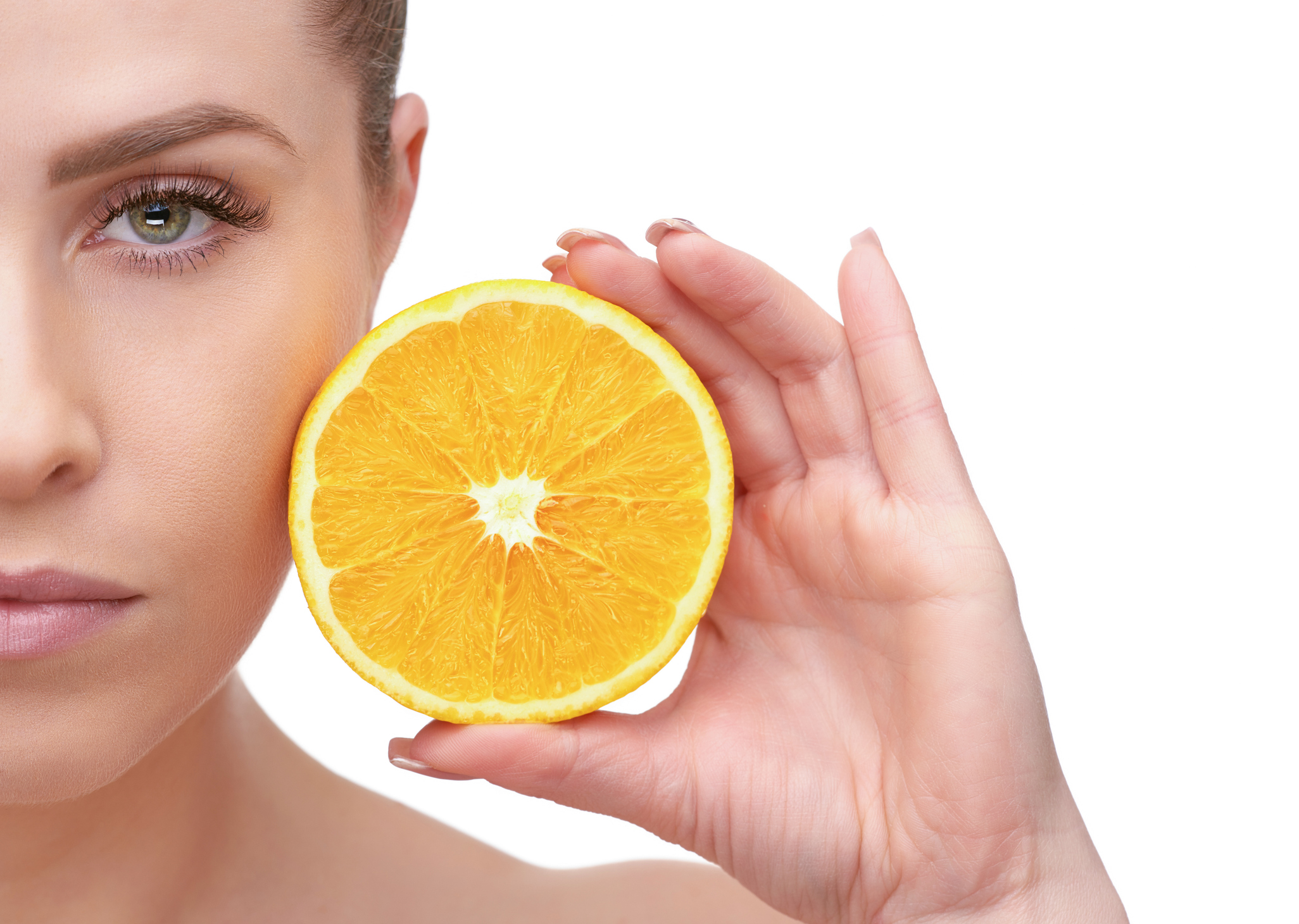 Woman holding lemon beside her face