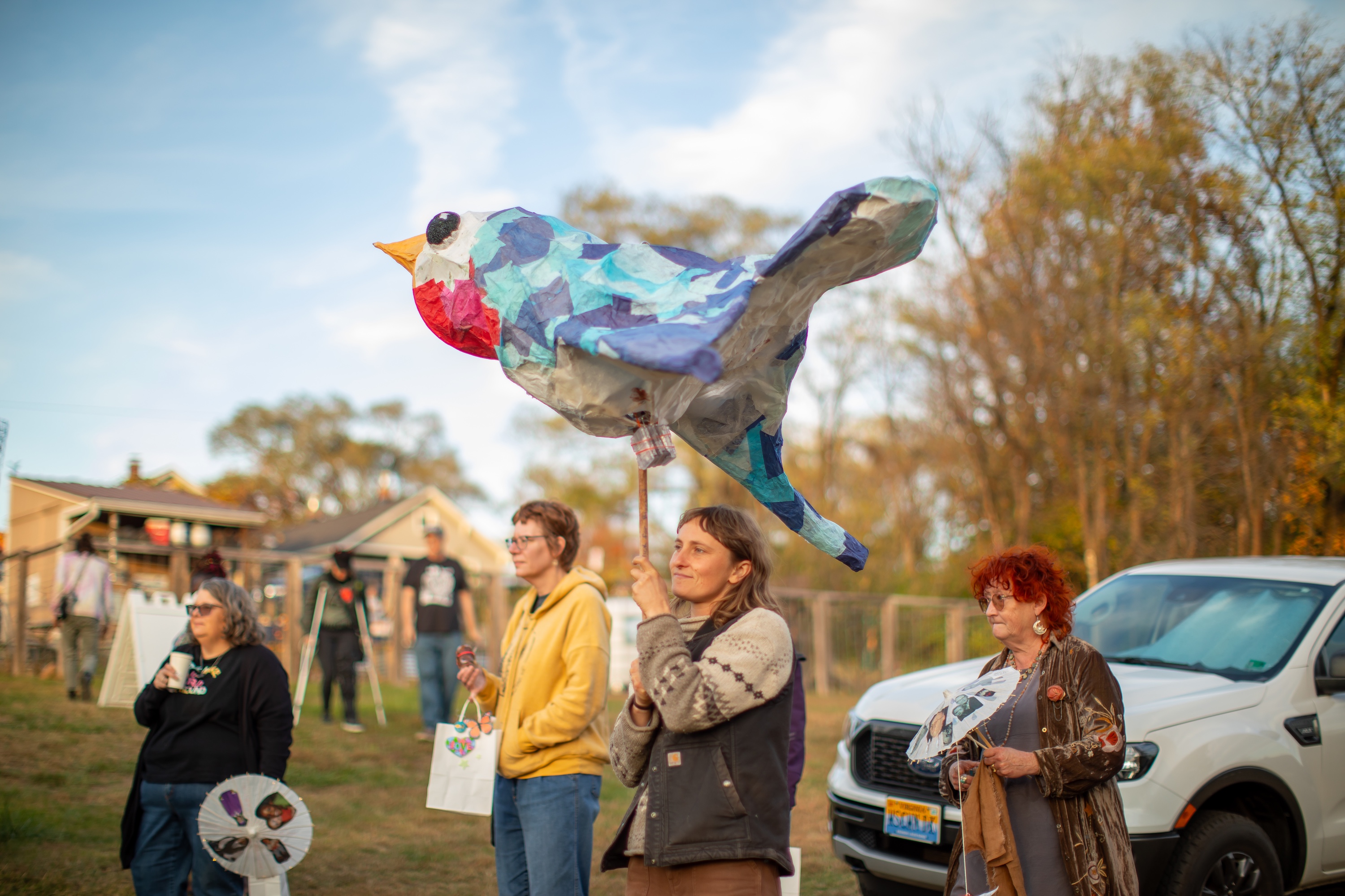 Farmer Hannah Patrick holds bluebird sculpture made by community members