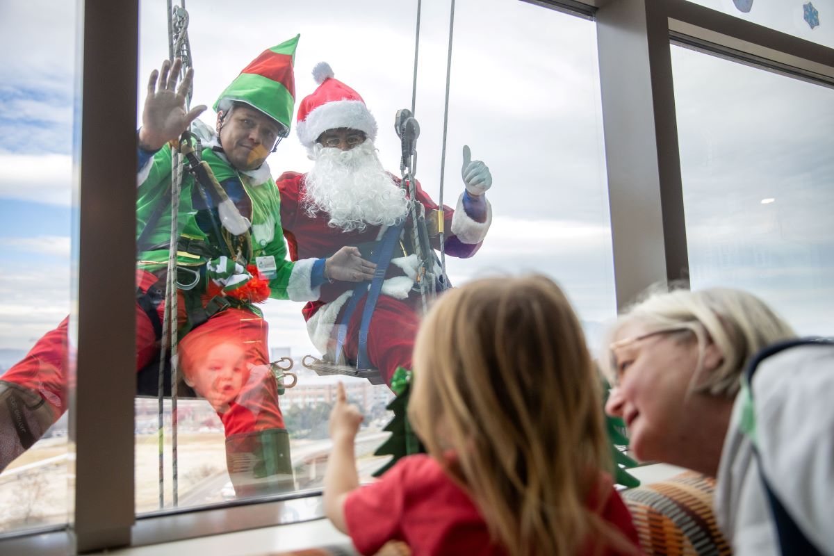 Santa and Elf waving to children