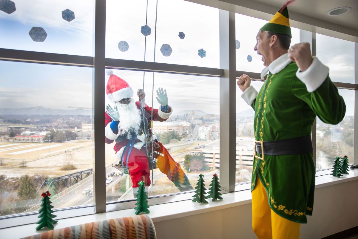 Santa waving at Buddy the Elf