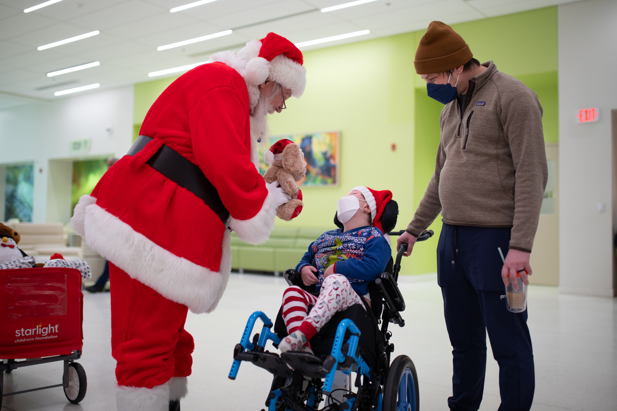 Santa greeting patient with stuffed toy