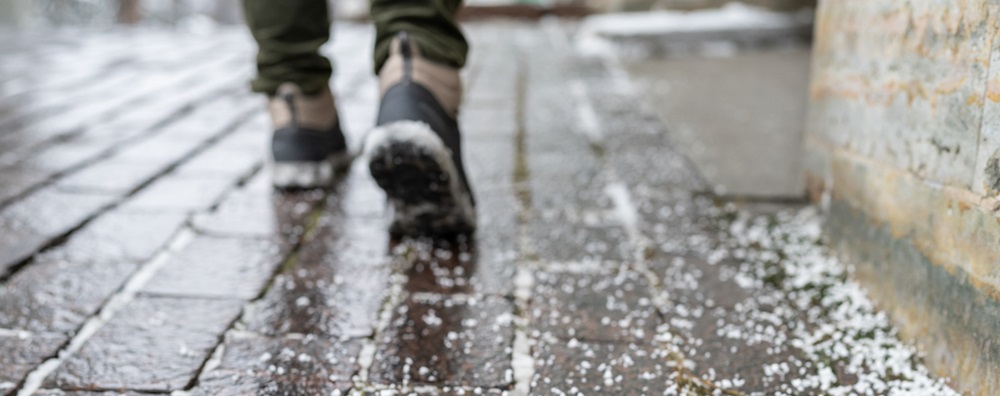 boots on an icy brick sidewalk