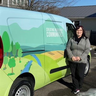 Jillian Smith, LPN, standing next to ID Mobile unit