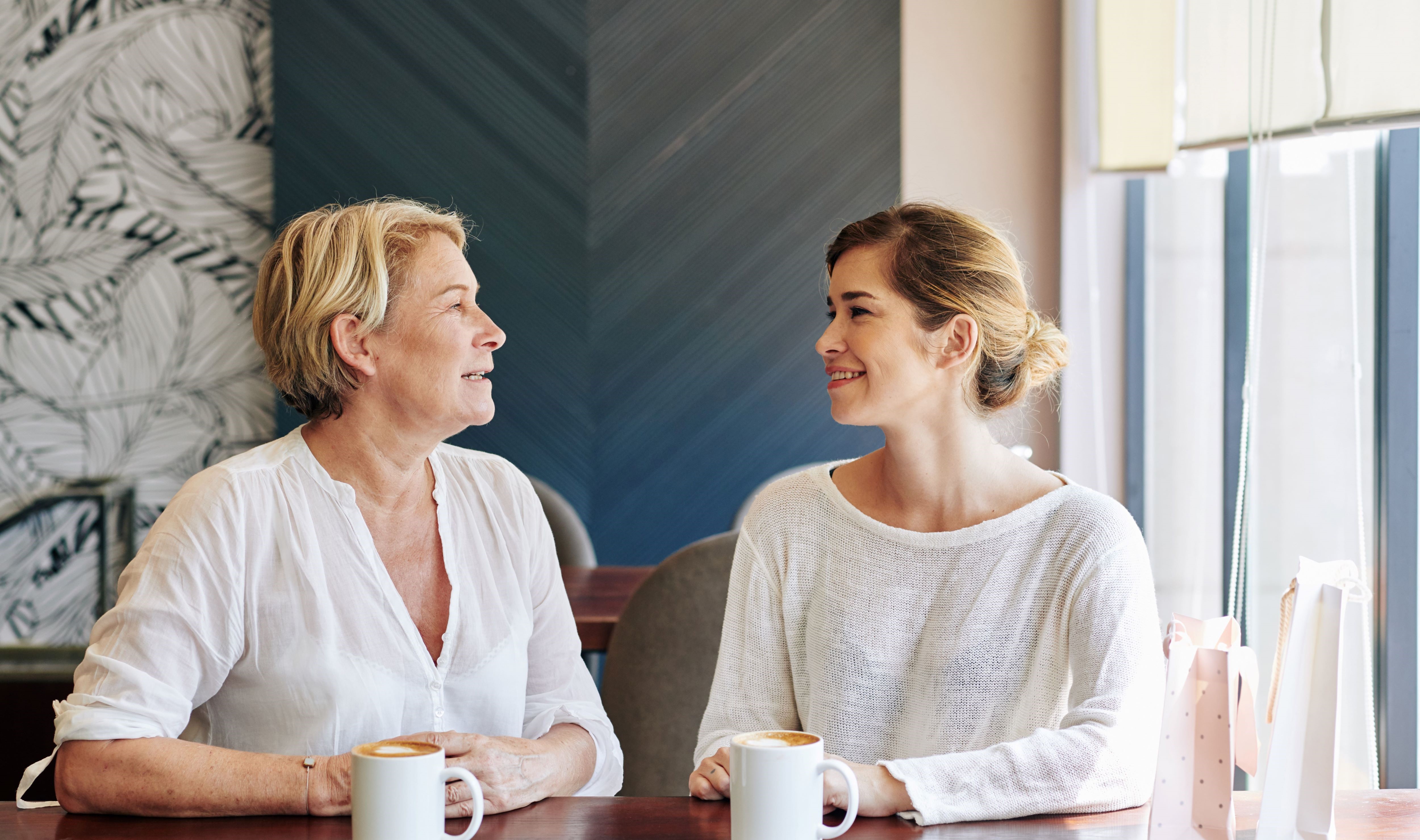 Mother and daughter talking while having coffee