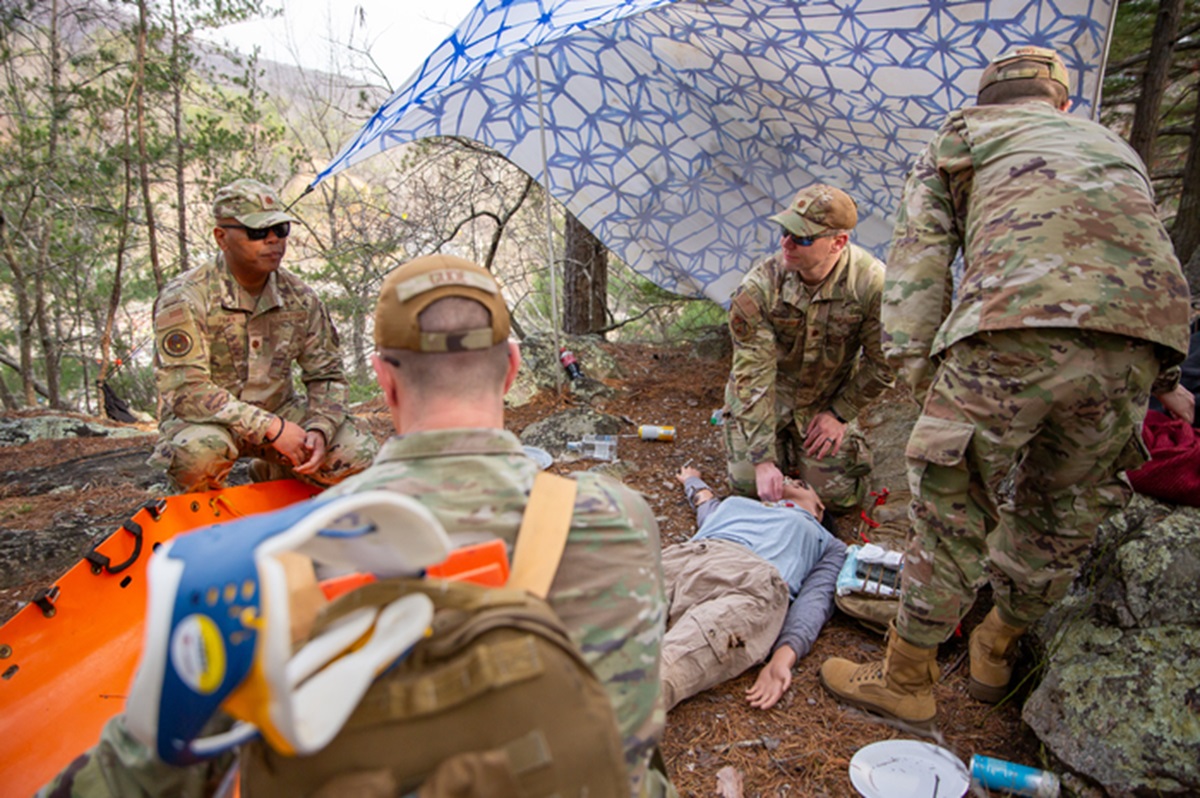 Guardsmen assess their first patient in the scenario. The patient is a manikin.