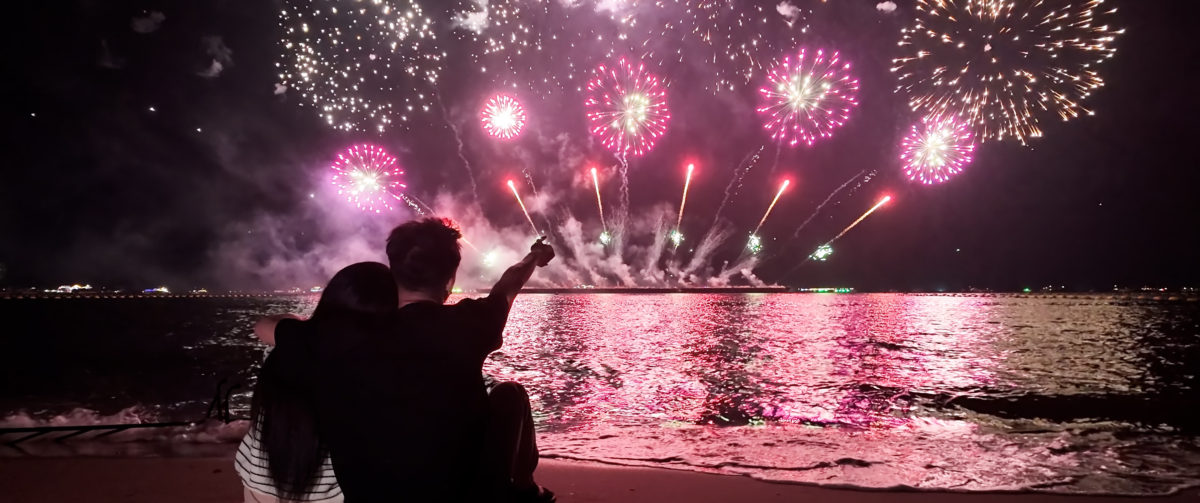 couple watching fireworks on a lake