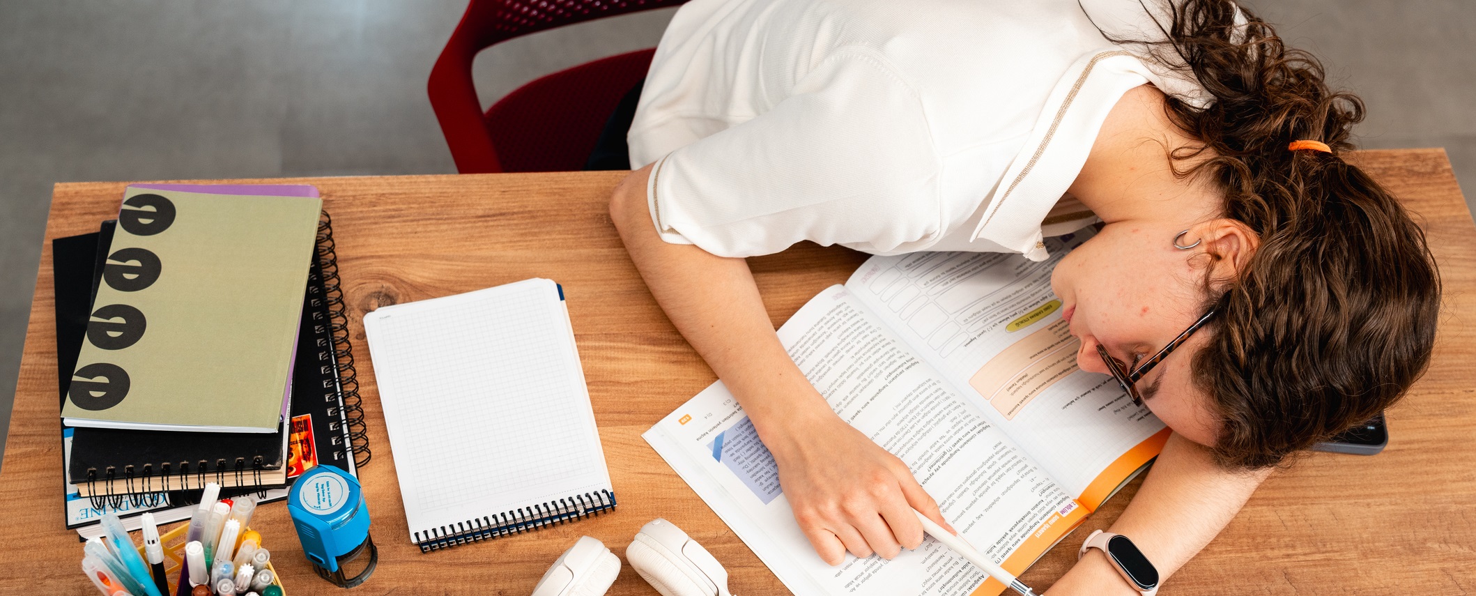 girl resting head on desk with homework