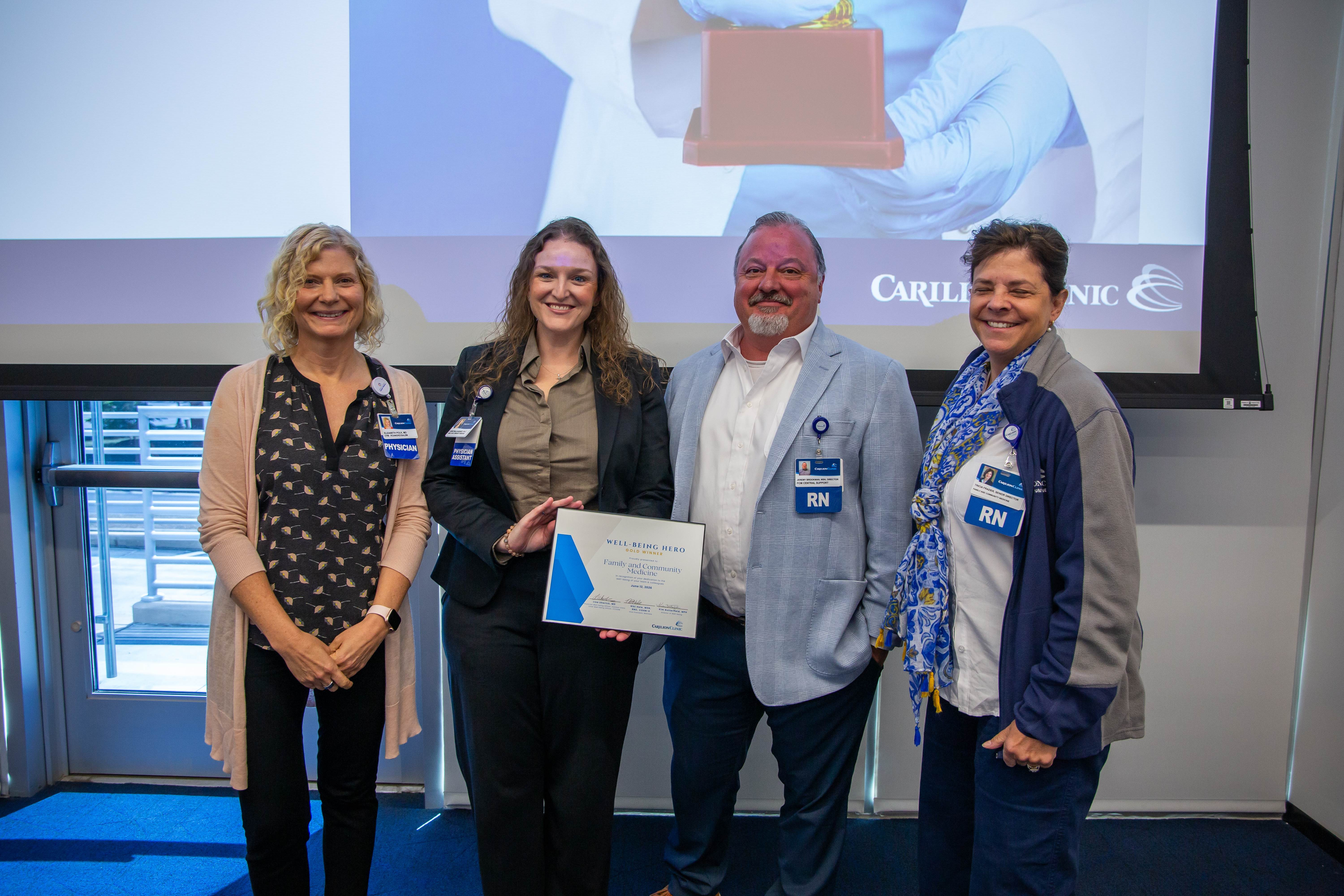 Trish Frazier, Dr. Beth Polk, Christina Gardner, and Jeremy Brookman accepting the Well-Being Team Gold award on behalf of Family and Community Medicine