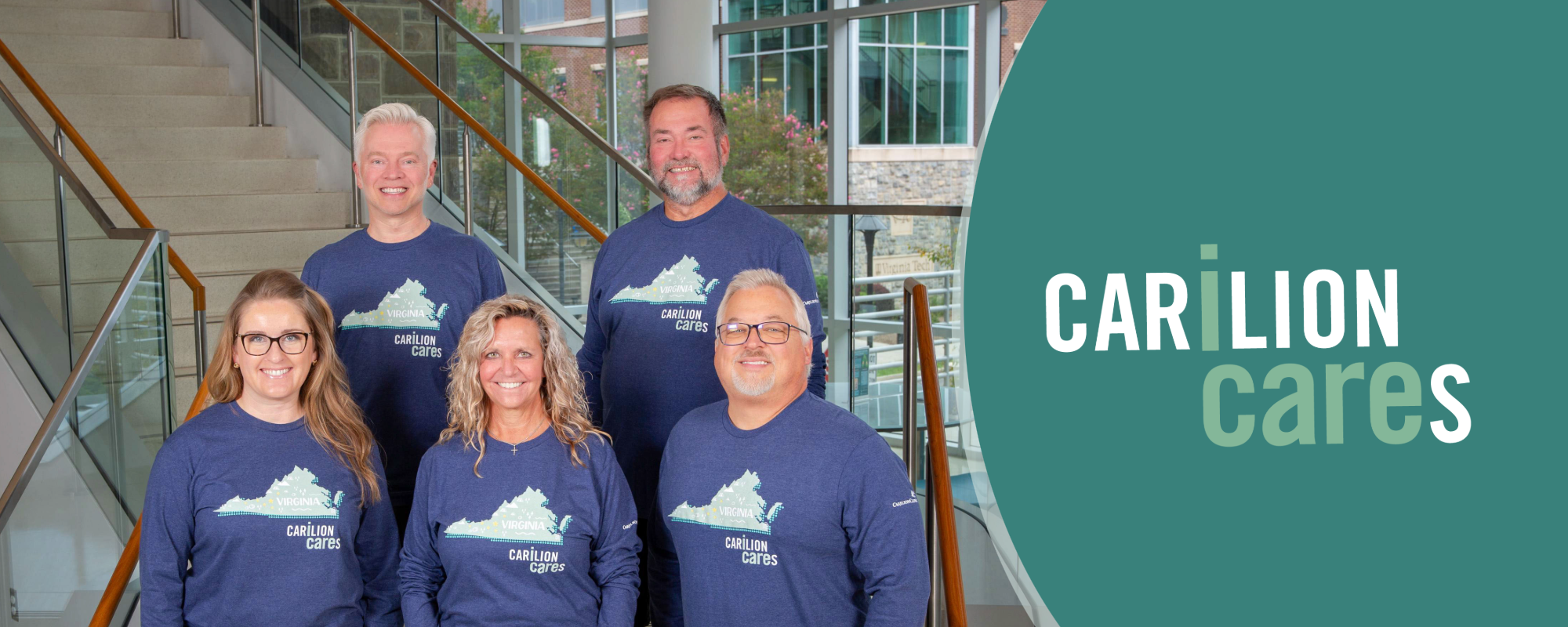 Five employees wearing the 2026 Carilion Cares, I Care t-shirts, smiling on a staircase with a green circle with the Carilion Cares, I Care logo on the right