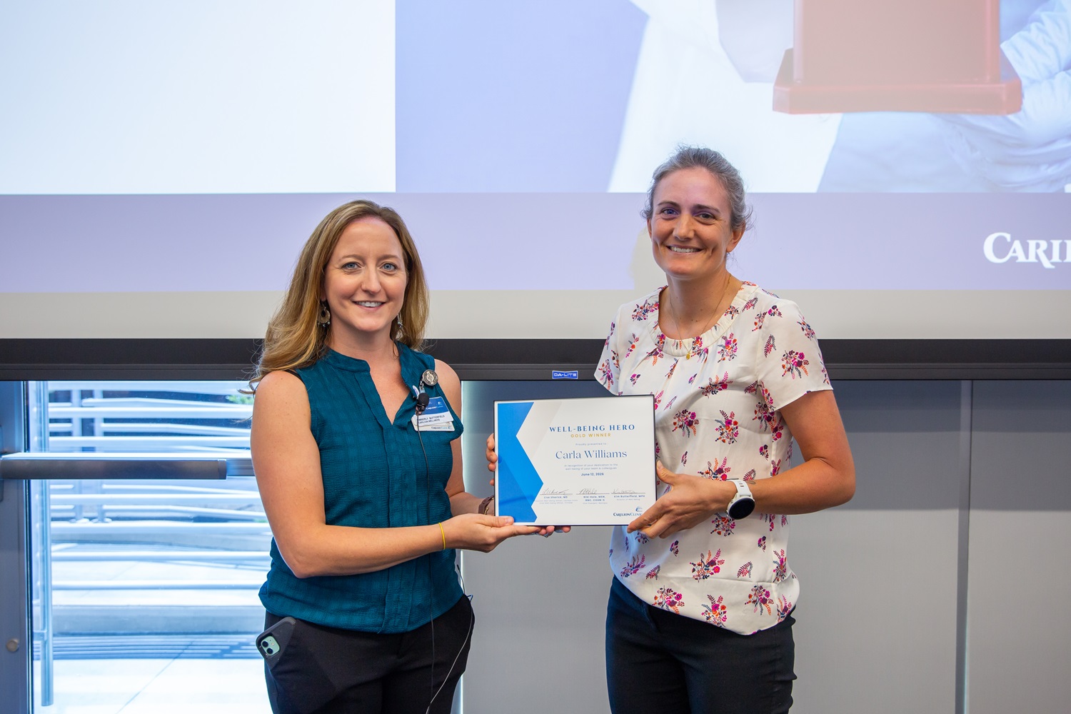 Carla Williams (right) received the Well-Being Hero Gold Award, presented by Kim Butterfield with Corporate Wellness (left).
