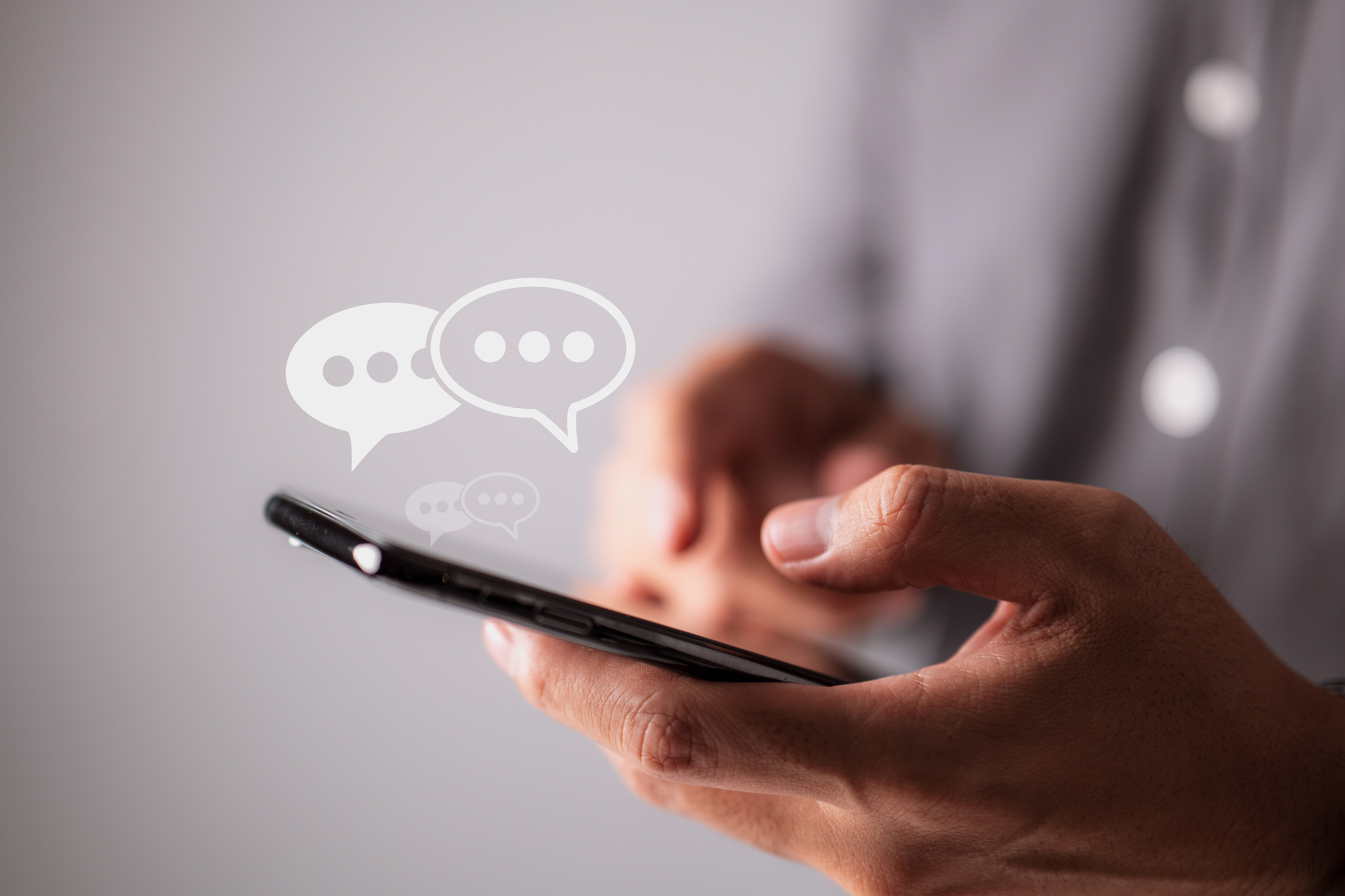text bubbles above a phone that someone is typing on