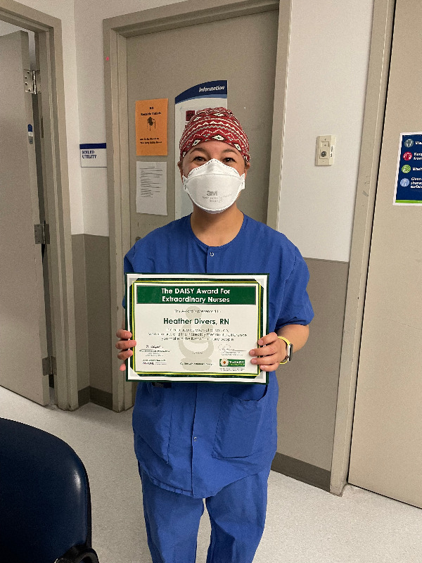Heather Divers holding her Daisy Award certificate.
