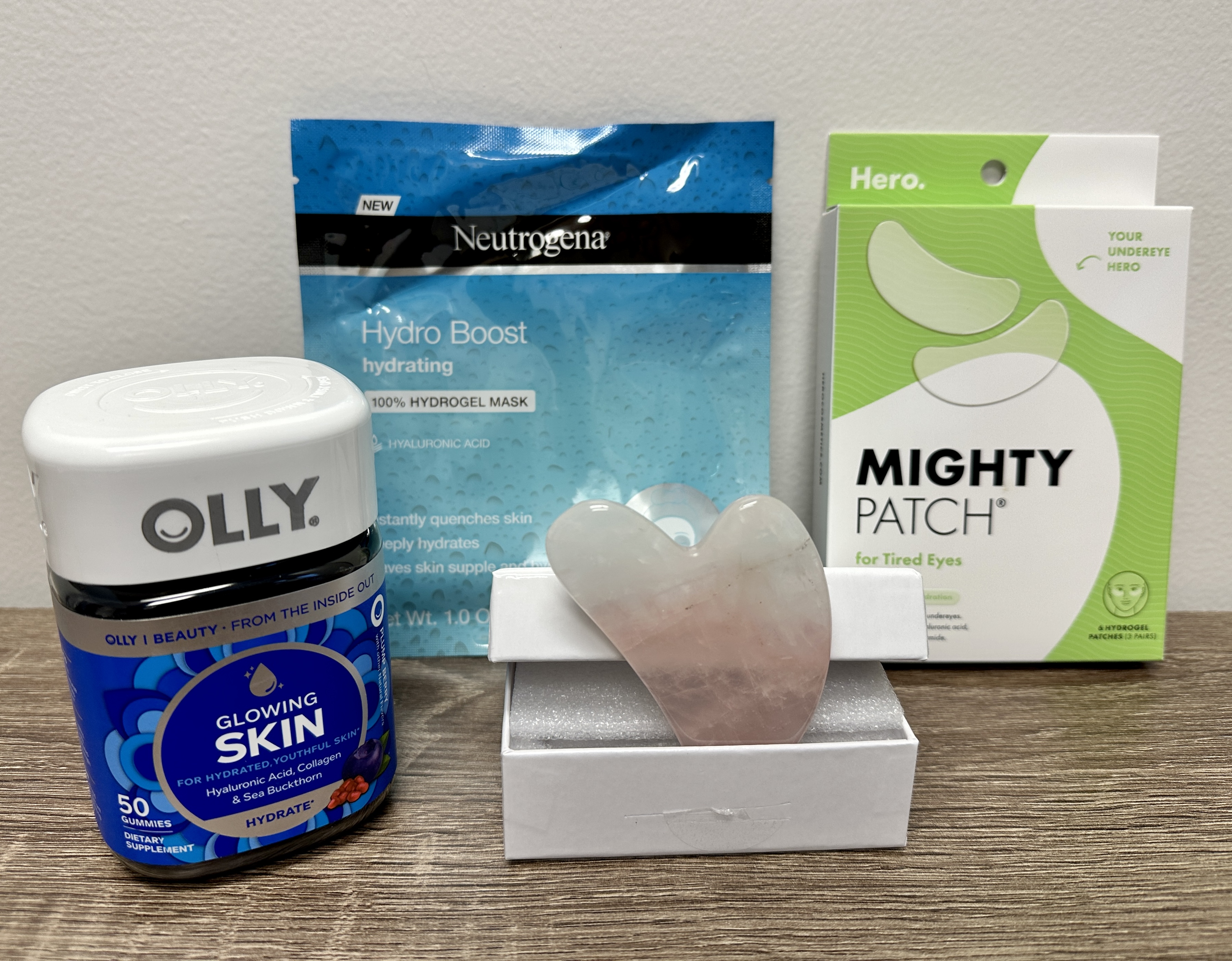 Box includes hydrogel mask, eye patches, gua sha tool, and "Glowing Skin" Olly supplements.
