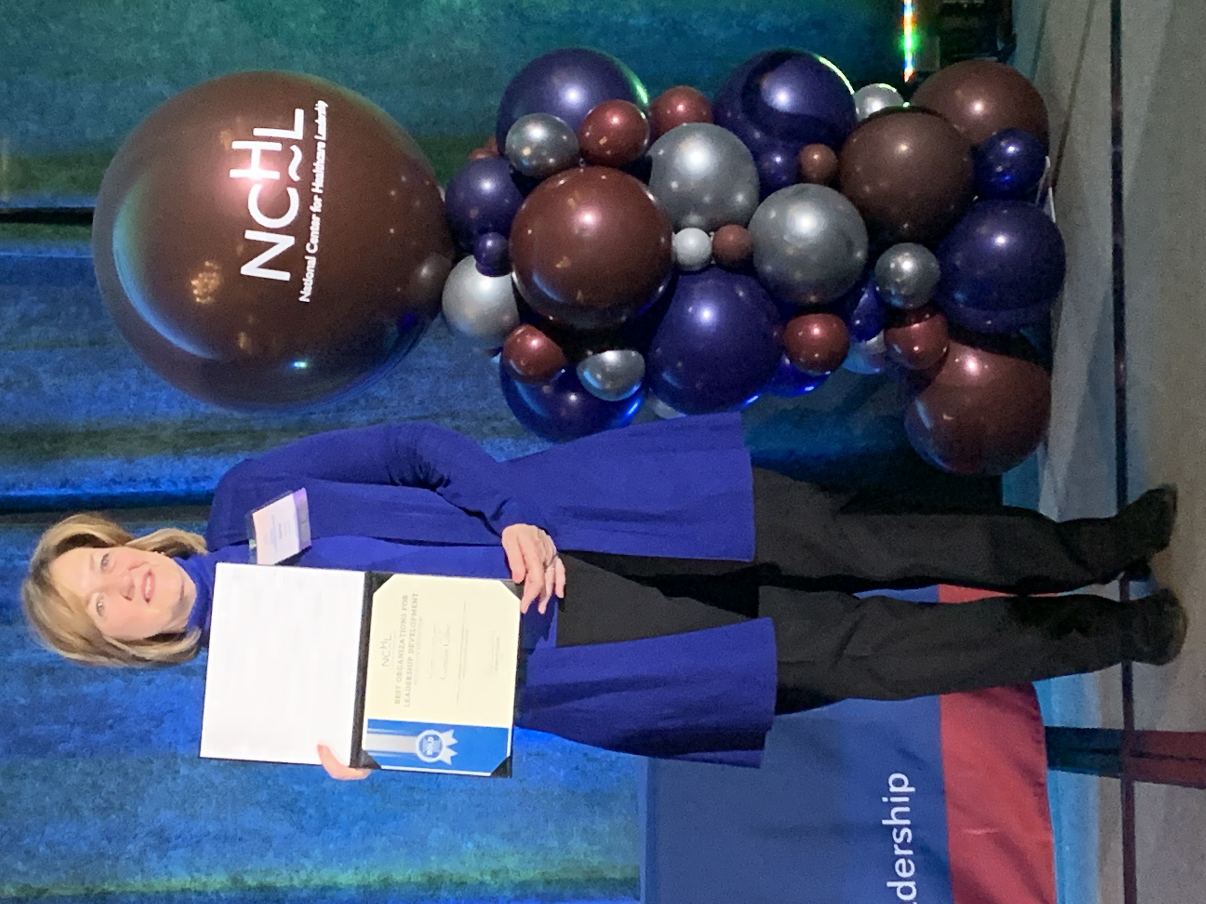Jeanne holding an award certificate