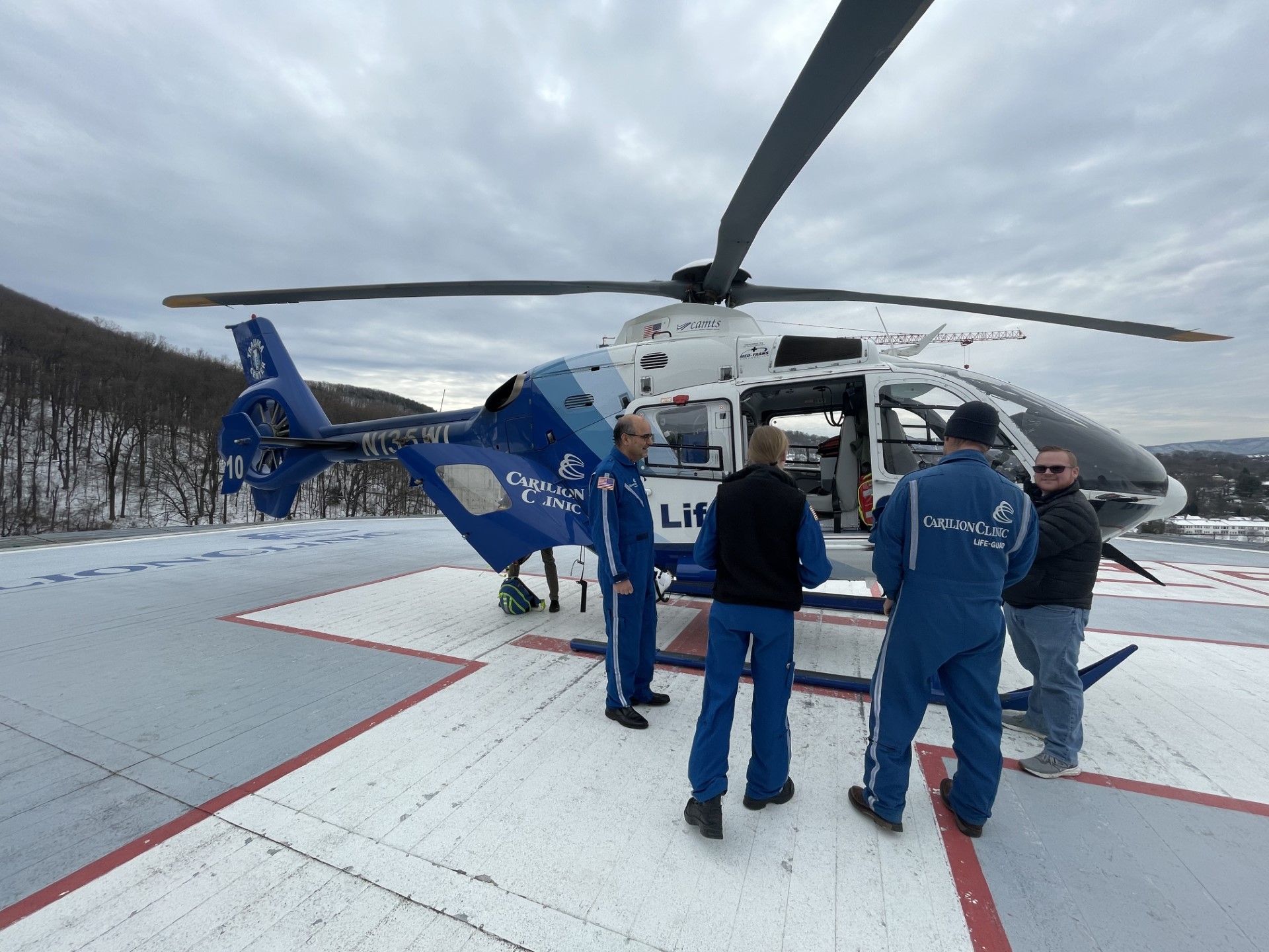 team discusses outside of the helicopter before boarding