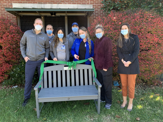 Team members from 8 Mountain ICU, Engineering and Maintenance, and Sustainability hold ribbon cutting for new bench