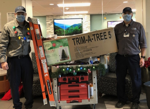 The lobby isn't the only thing the maintenance workers decorated. Rob (left) and Seth haul a holiday tree on their work cart that they tricked out with holiday ornaments.