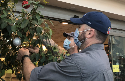 Seth Spence (front) and Rob Dickinson made time between work orders to decorate trees, hang garland and put up lights. The safety-conscious electricians used battery-operated lights.