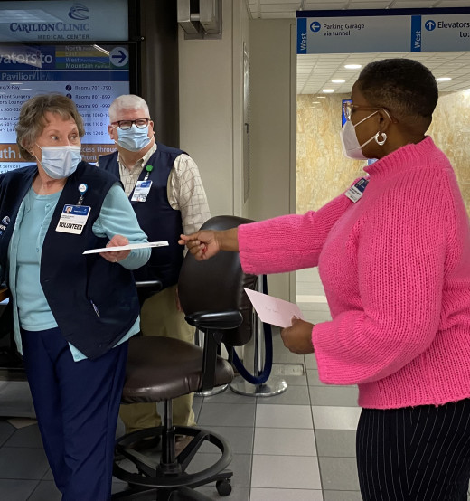 Guest Services Director Shanna Flowers (right) surprises volunteers Carol and Roger Foutz in the CRMH Main Lobby.