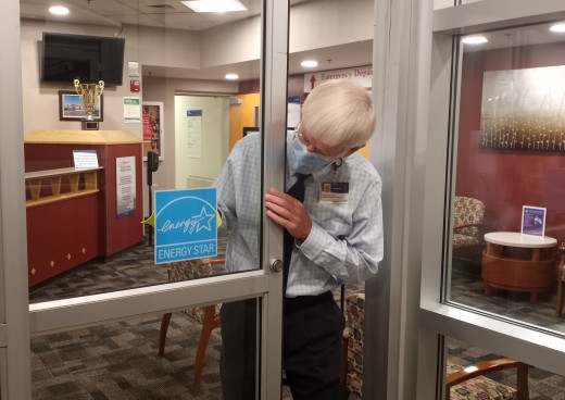 Mark Kaldahl, CFMH Facility Support Director, hanging up the Energy Star decal