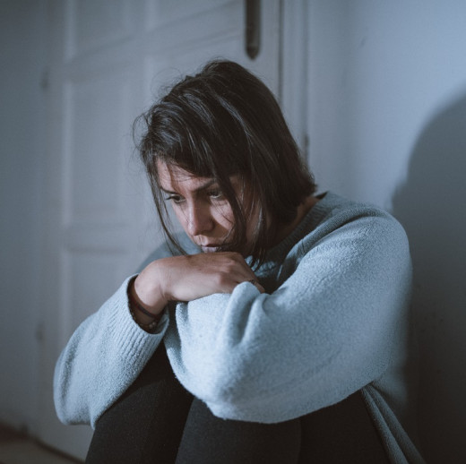 sad woman sitting in front of a door