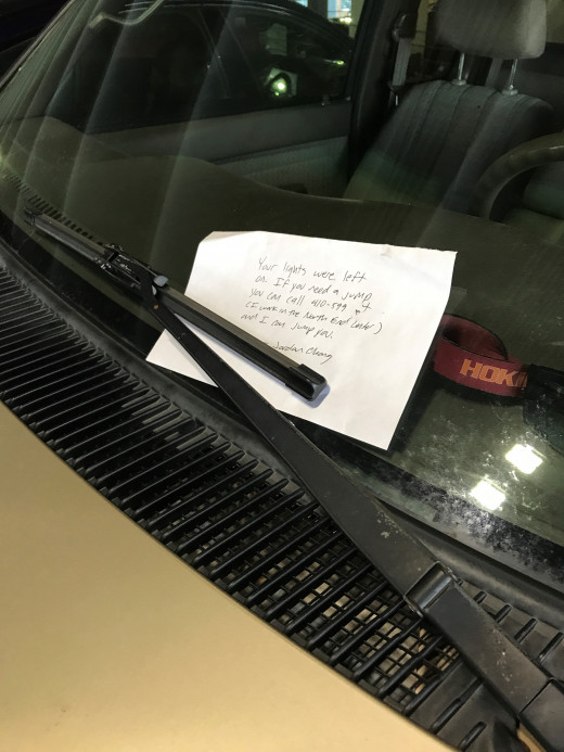 Image of a note left on a vehicle windshield offering help if needed. 