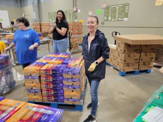  Sherry Hartsel, Cara Basham, and Leslie Wyatt smiling as they are doing volunteer work.