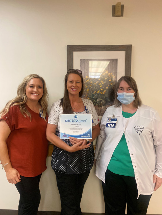 Alicia Bales, Senior Director and Kim Brown, Nursing Unit Manager present a Great Catch Award to Cindy Holbrook, RN