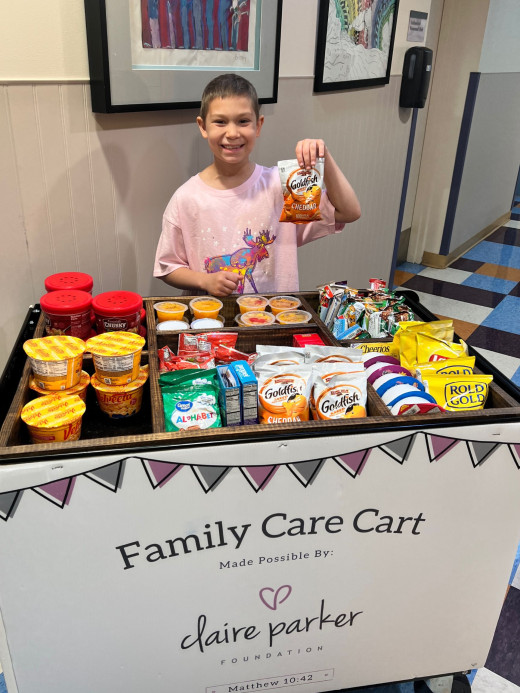 A pediatric oncology patient picks a snack from the Family Care Cart. 