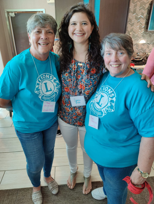 Lion's Club Volunteers Smiling with Childhood Cancer Survivor